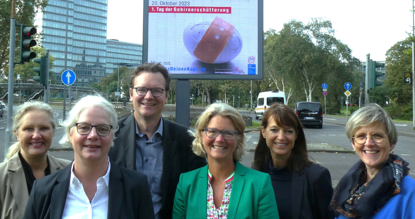 Dr. Susanne Schaefer zusammen mit Unterstützern der Zurich steht vor einer Werbung für das TdG 2023