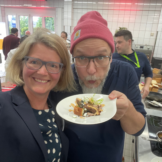 Dr. Susanne Schaefer und ein Herr machen ein Selfie mit einem schön hergerichteten Teller