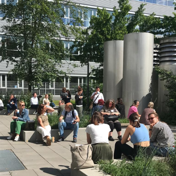 Menschen sitzen draußen und unterhalten sich